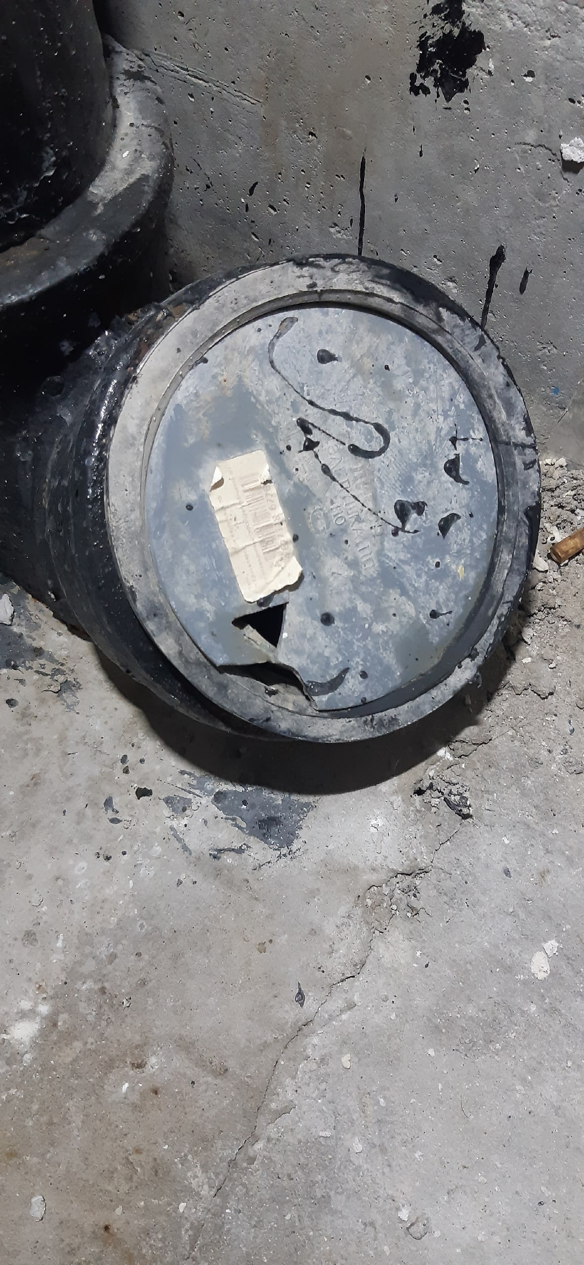 Поврежденная крышка канализационного узла на полу с отметками дефектов